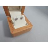 A pair of single stone diamond earstuds in 18ct white gold, each post headed by a collet set round