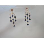 A pair of sapphire and moonstone chandelier earrings, each post headed by a collet set round