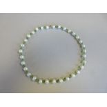 A peridot and cultured pearl necklace, composed of 4.7mm round peridot beads alternating with