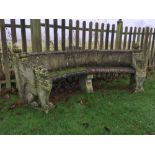 A composite stone curved bench, with raised panel back and on seated lion end supports 91 x 233 x