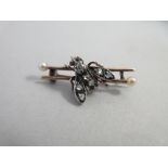 A Victorian diamond and pearl set insect brooch, designed as twin bars each with one seed pearl