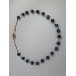 A lapis lazuli bead necklace with a Georgian seed pearl clasp, the 12mm beads with short chain