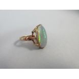 A large single stone Australian opal ring, the oval shallow cabochon opal, measuring 9.2 x 6.5 x 5.