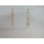 A pair of opal and citrine earpendants, each hook suspending a line of two oval cabochon jelly opals