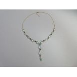 An aquamarine and sapphire necklace, composed of graduated pear cut aquamarines set in a line and