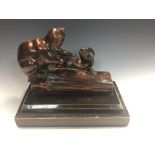 A carved beaver group, modelled climbing on a log and mounted to a stepped ebonised plinth base 22 x