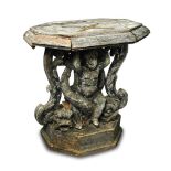 An 18th century carved wood pedestal of entwined dolphin, cherub and scroll design, supporting a