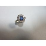 A sapphire and diamond cluster ring, the oval cut sapphire collet set to a border of old round cut