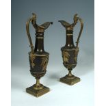 A pair of French Empire gilt and patinated bronze ewers, each ewer with a handle cast as the head of