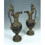 A large pair of Renaissance revival patinated bronze ewers, each cast with a frieze of Bacchic putti