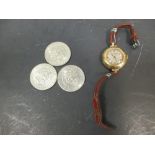 A lady’s vintage 18ct gold Jaeger-le-Coultre circular wristwatch and three Kennedy half dollars, the