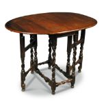 A small 18th century oak gate leg table, on turned end joint supports, terminating on out swept