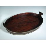 A George III brass bound mahogany tray, of oval form with turned handles 59cm (23in) The brass