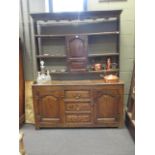 An 18th century oak Welsh dresser with raised open plate rack and spice cupboard, the base with