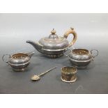 A silver three piece tea set and a napkin ring and teaspoon, 14oz (including the handle)