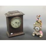 A Paris porcelain encased clock surmounted by a figure, together with a wooden cased clock (2)