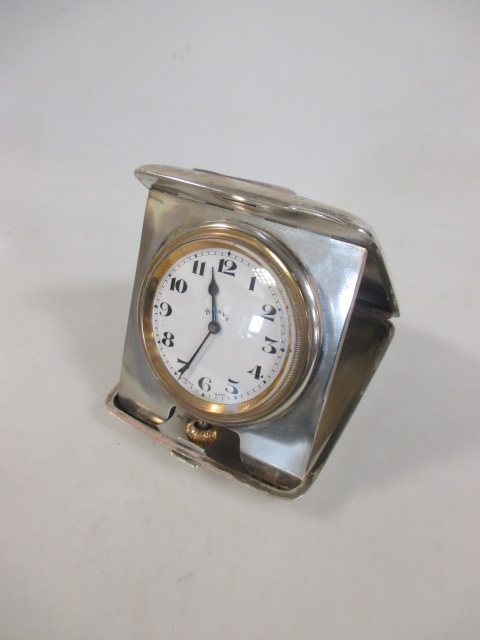 An early 20th century silver cased 8 day travel clock, with Arabic numerals