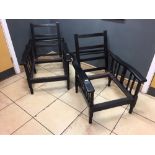 A pair of Arts & Crafts ebonised reclining chairs, each with adjustable backs and shaped arms on