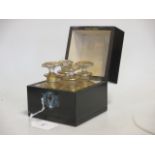 A late 19th century ebonised and inlaid decanter box fitted with four small gilt glass bottles and