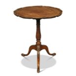 A George III mahogany tripod table, with circular pie-crust moulded top, on a later leaf carved