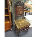 An 18th and later oak joined chair with carved armorial panel depicting a boar