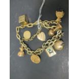 A two strand charm bracelet and charms including a 1908 half sovereign, 46.1g gross