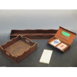 Two mahogany desk trays and a cased pack of playing cards