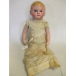 An early 20th century doll, painted blonde hair and blue eyes