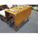 A drop leaf mahogany table with claw and ball feet