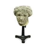 A weathered stone head after the antique, mounted to a cast iron stand 56cm (22in)