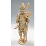 An early 20th century marine ivory sectional figure of a monk, he stands holding a drum topped staff