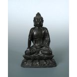 An 18th/19th century bronze Buddha seated cross legged on a double lotus throne, his right hand