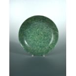 A spinach green jade deep dish, the mottled green stone with a speckling of black inclusions,