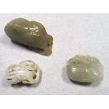 Three jade pendants, the largest of aubergine shape topped by foliage, 6cm (2.25 in) high, one