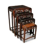 A nest of four hardwood tables, the sides of the dished rectangular tops rounding down into the