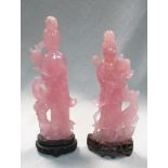 A pair of rose quartz ladies with wood stands, carved as mirror images, they stand by phoenix