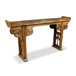 A 19th century elm altar table, the rectangular top rising up at each end above pilaster legs
