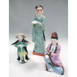 Three 20th century porcelain figures, the tallest of a green robed man holding a book, 28cm (11