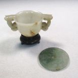 A jade two handled censer, wood stand together with a jade bi, the sides of the censer line carved