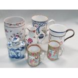 Five 18th and 19th century mugs, a jug, a blue and white tea caddy and cover, the three famille rose