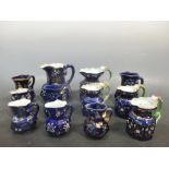 Twelve Mason's blue jugs painted with coloured flowers