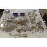 A group of silver to include two mustards, a pair of salts, five pepperettes, three napkin rings etc