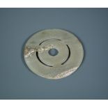 A Chinese jade bi disc, possibly Han dynasty, 8.5cm (3.25 in) diameter