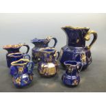 Seven Mason's blue jugs gilt with flowers