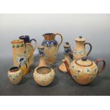 A collection of Doulton salt glazed stonewares, including a four piece tea set, a pair of