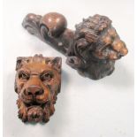 A carved capitol of a lion's head, another similar carving, a turned wood bowl and other wooden