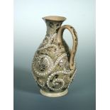 George Tinworth for Doulton Lambeth, a stoneware jug, with incised scroll work and applied