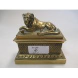 A Regency polished bronze inkwell with reclining lion lid