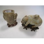 A 19th century Chinese jade boy on a buffalo, a jade libation cup and wood stands