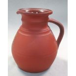 A 19th century Wegwood terracotta ale jug, the ovoid body applied in gilt with the crest of St
